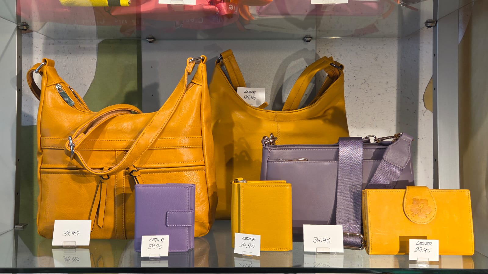 Gelbe und lila Lederhandtaschen und Geldbörsen bei in-bag Wien