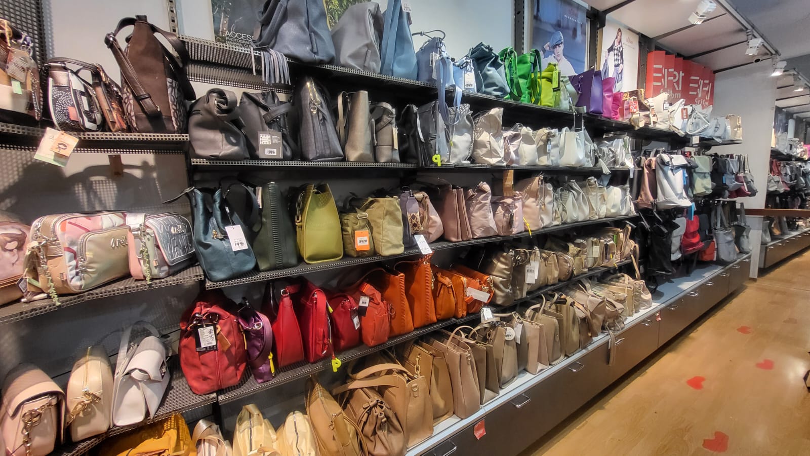 Bunte Taschen und Rucksäcke im Regal bei in-bag Wien